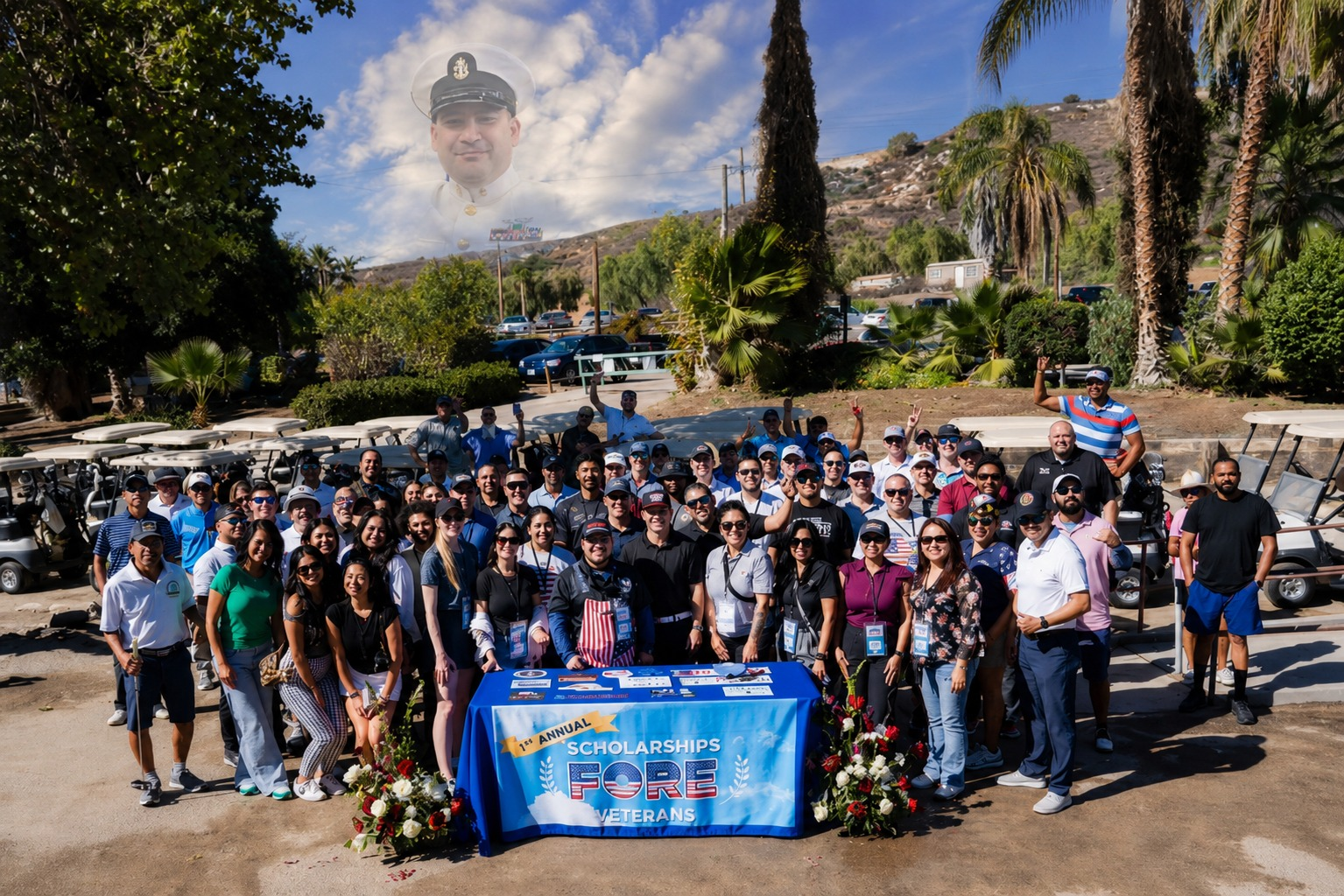 The Scholarships FORE Veterans community gathered behind the event table banner at Carlton Oaks Golf Club, with a memorial portrait of Senior Chief Loleni “Leni” Talo in the sky above.